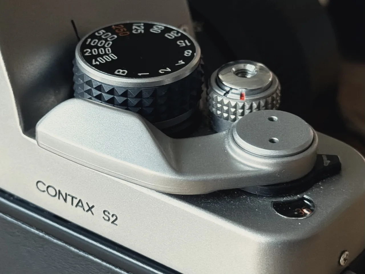Close-up of the S2's shutter speed dial, with 1/250 marked in orange, beside the shutter button and film advance lever