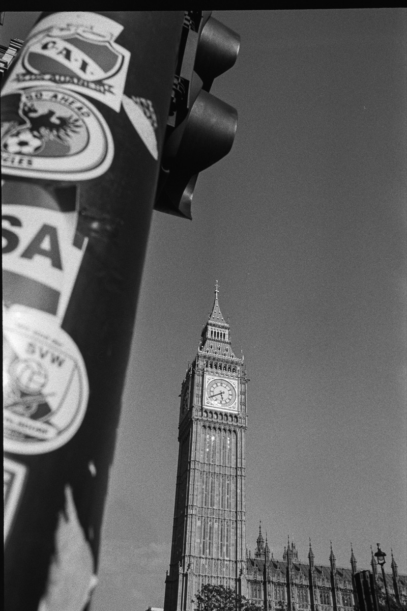 Big Ben behind a sticker-covered traffic light