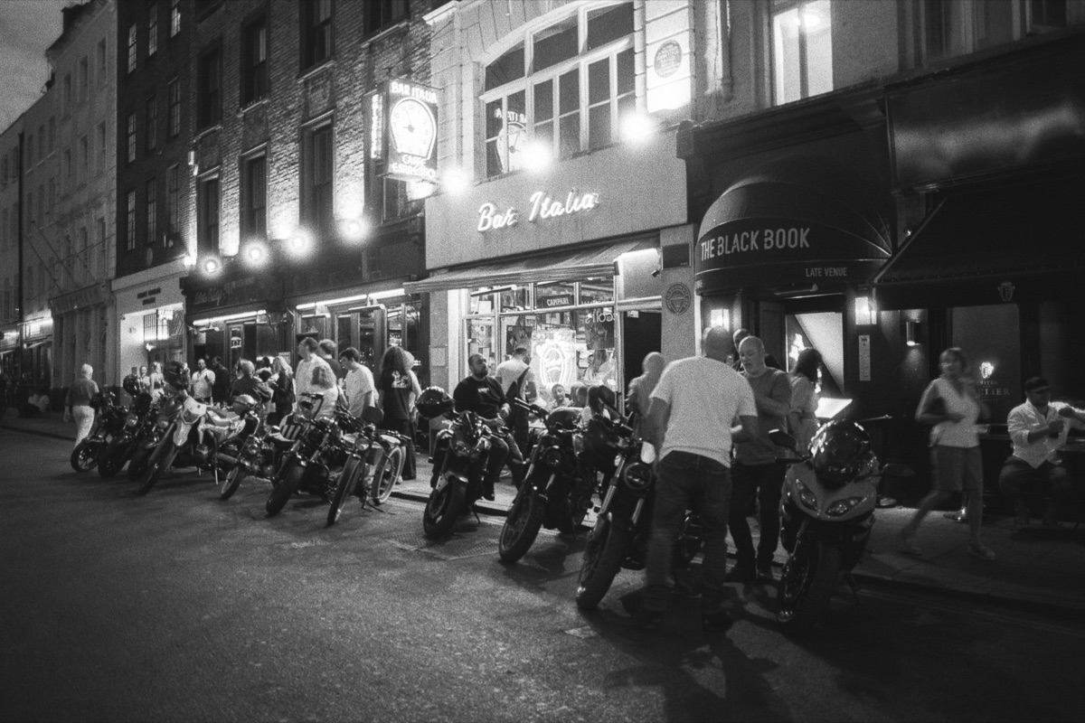 Motorbikes lined up on a street at night