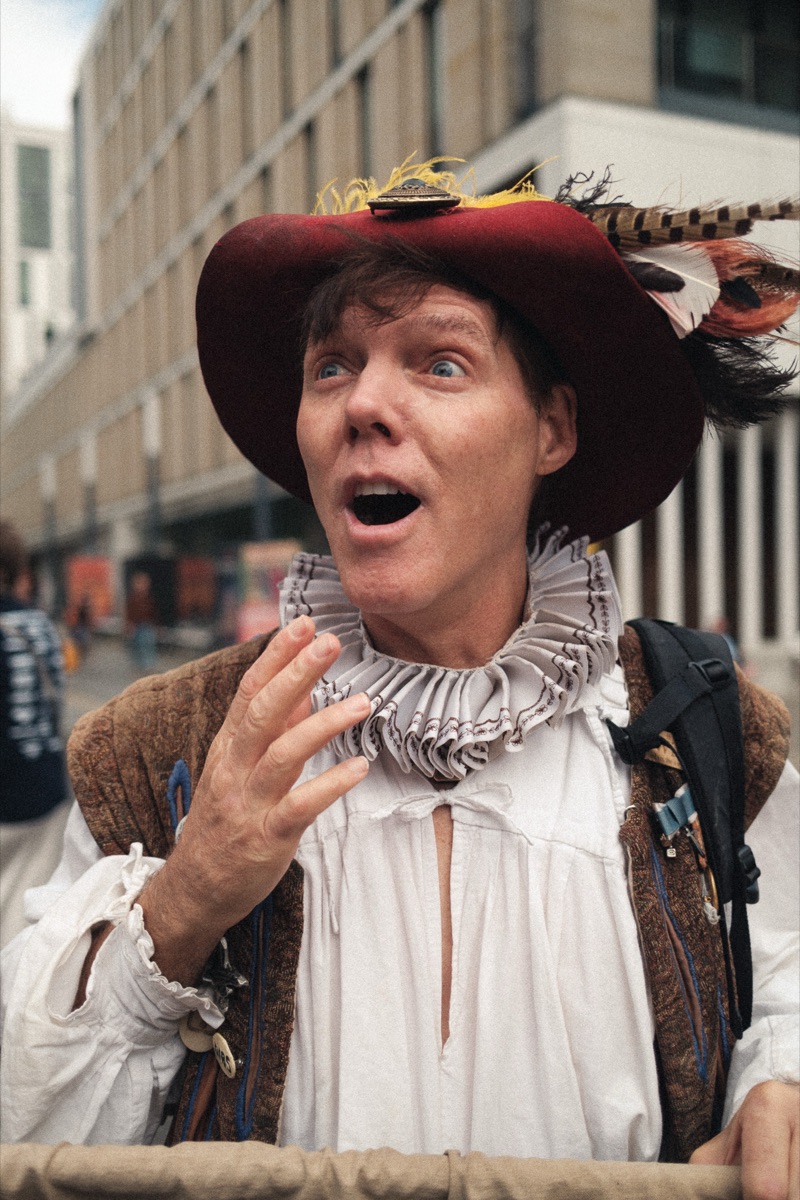 Performer in a ruff collar and feathered hat