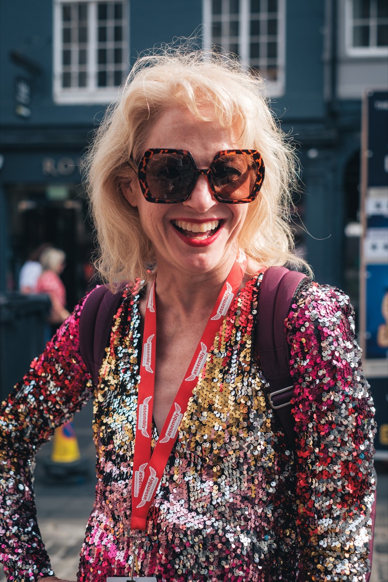 Woman in a sequin jacket laughing