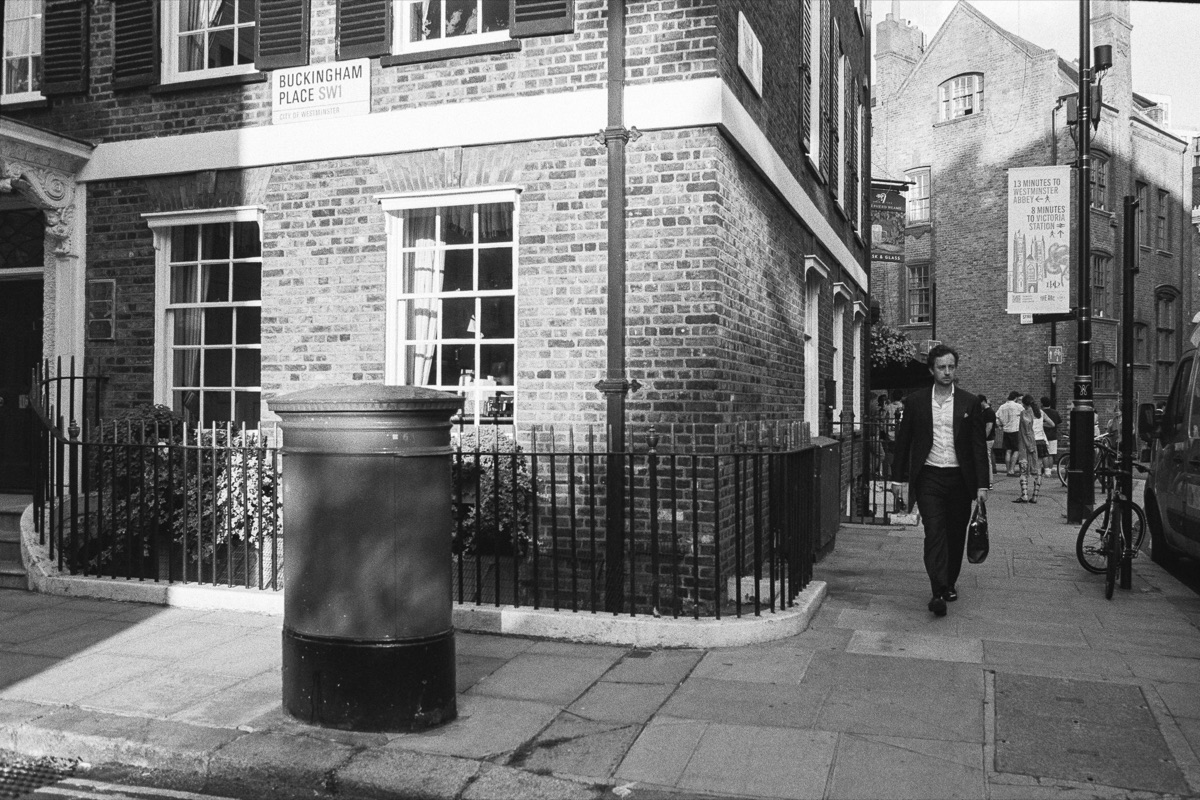Street corner with bollard and passing man